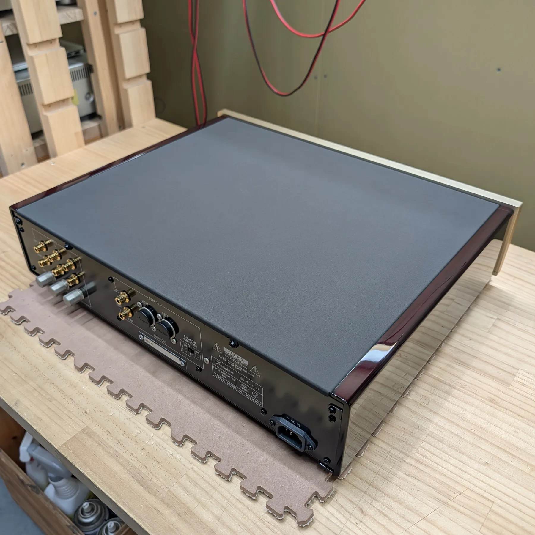 アキュフェーズ C-37 フォノイコライザーの斜め後ろから見た外観、長方形筐体、天板はダークグレーの梨地仕上げ、光沢のある赤茶色の側面、背面は黒色金属製で入力