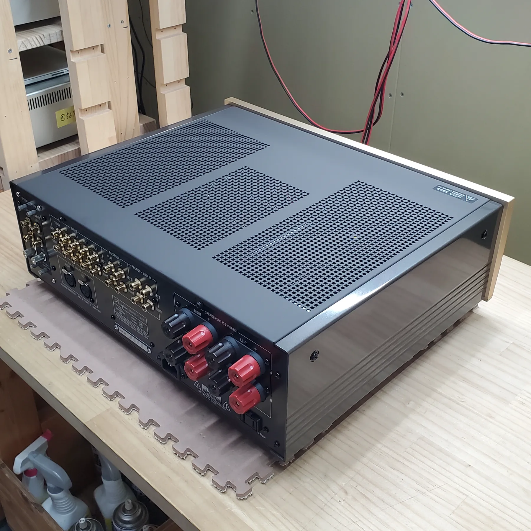 アキュフェーズ E-3000 プリメインアンプの斜め後ろから見た外観、天板はダークグレー金属製で通気孔、右側面はシャンパンゴールド木目調パネルと光沢あるダークグレー放熱フィン