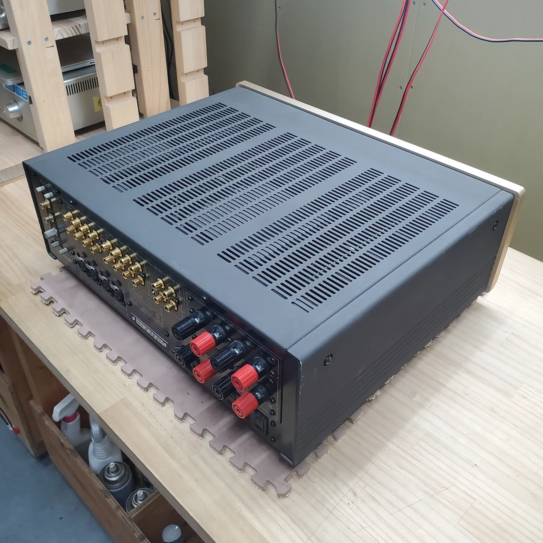 アキュフェーズ E-307 プリメインアンプの斜め後ろから見た外観、直方体筐体、天板はダークグレーで放熱スリット、側面はフィン、シャンパンゴールドヘアラインサイドパネル、背面は金色のRCA端子、スピーカー端子