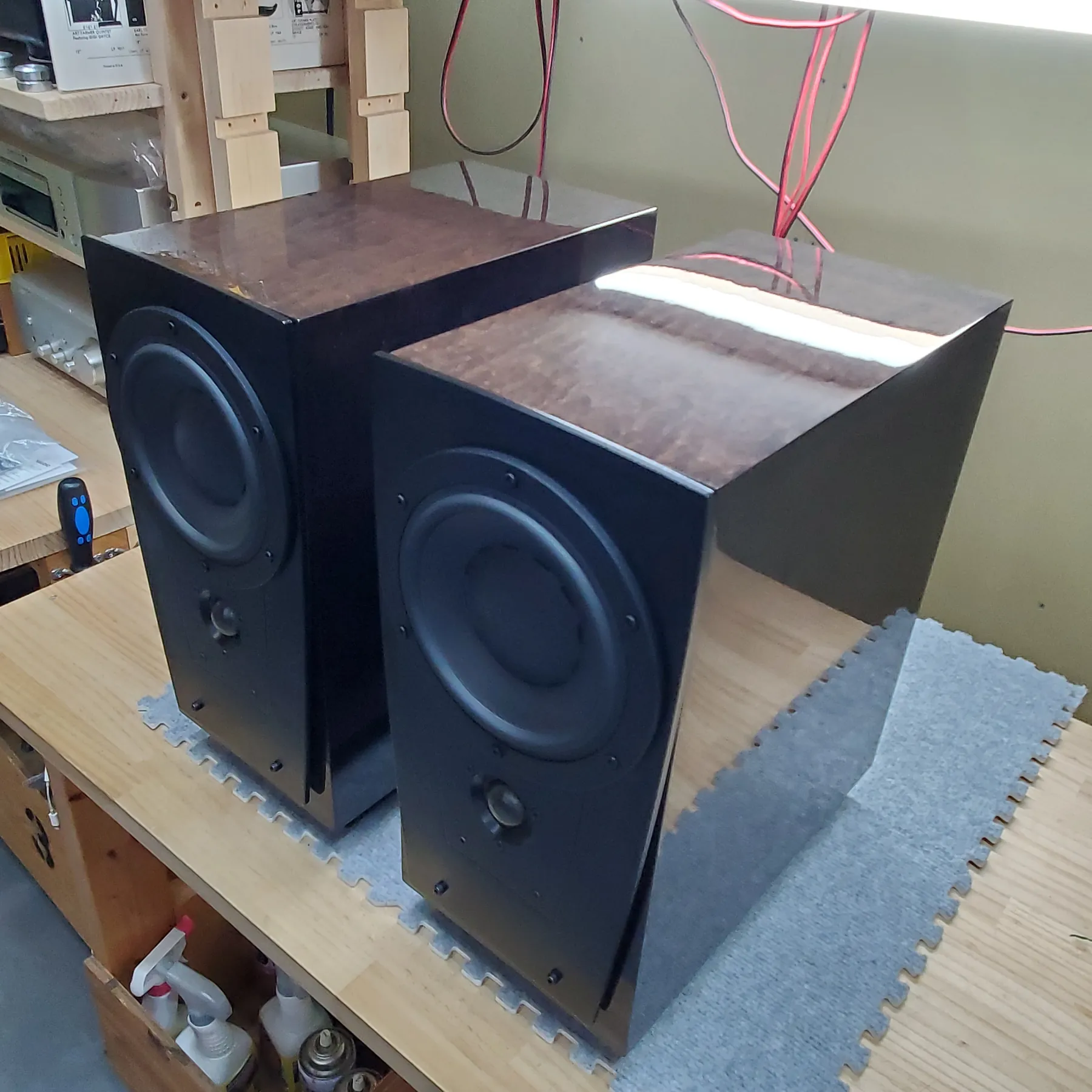 ディナウディオ CONTOUR S1.4LE スピーカーの斜め前から見た外観、筐体は黒色光沢仕上げ、天板は赤茶色の木目調光沢仕上げ、前面パネルに大小2つの円形スピーカーユニットを配置