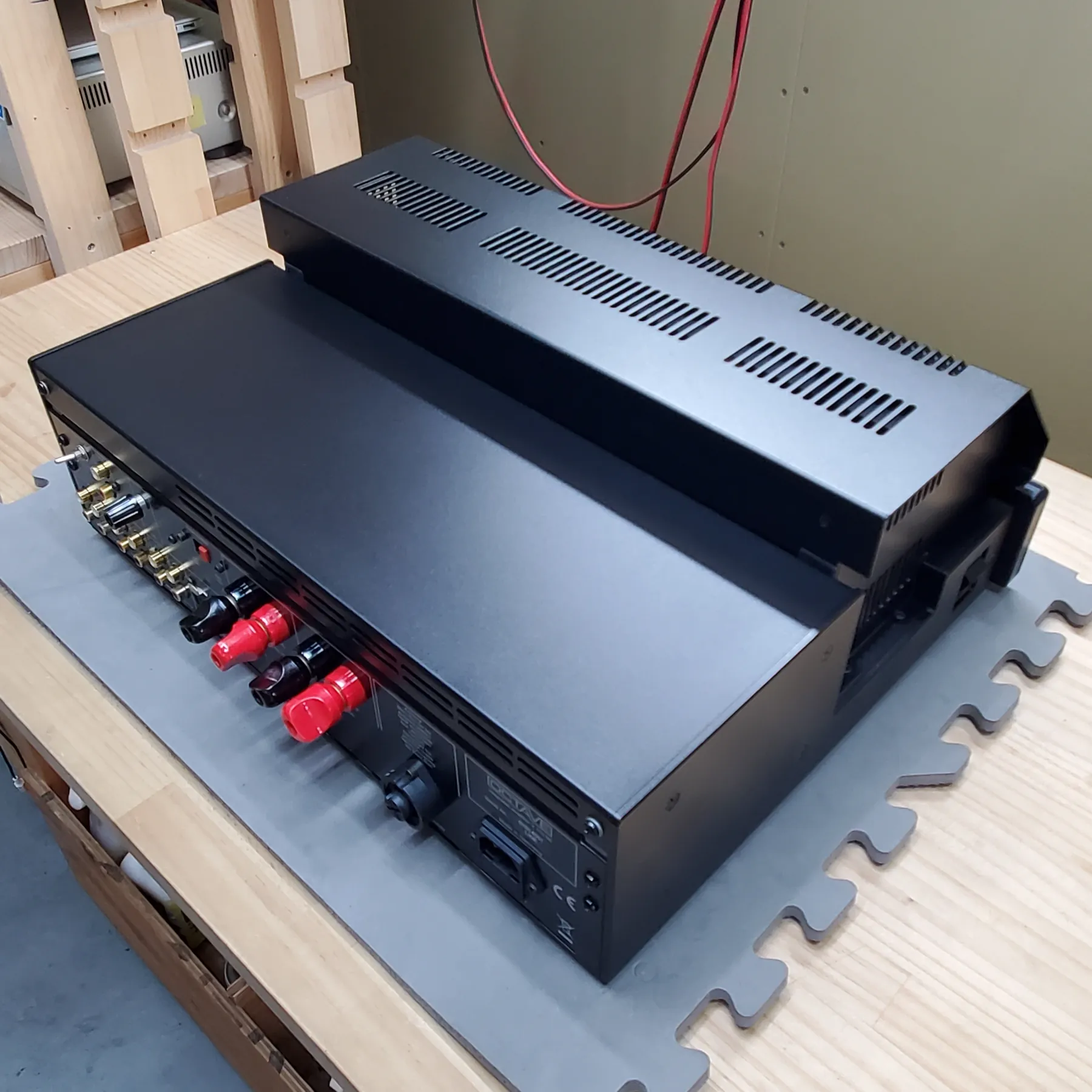 オクターブ V110SE LINE プリメインアンプの斜め後ろから見た外観、黒色マット仕上げの金属製筐体、天板に通気孔付きユニットが載る