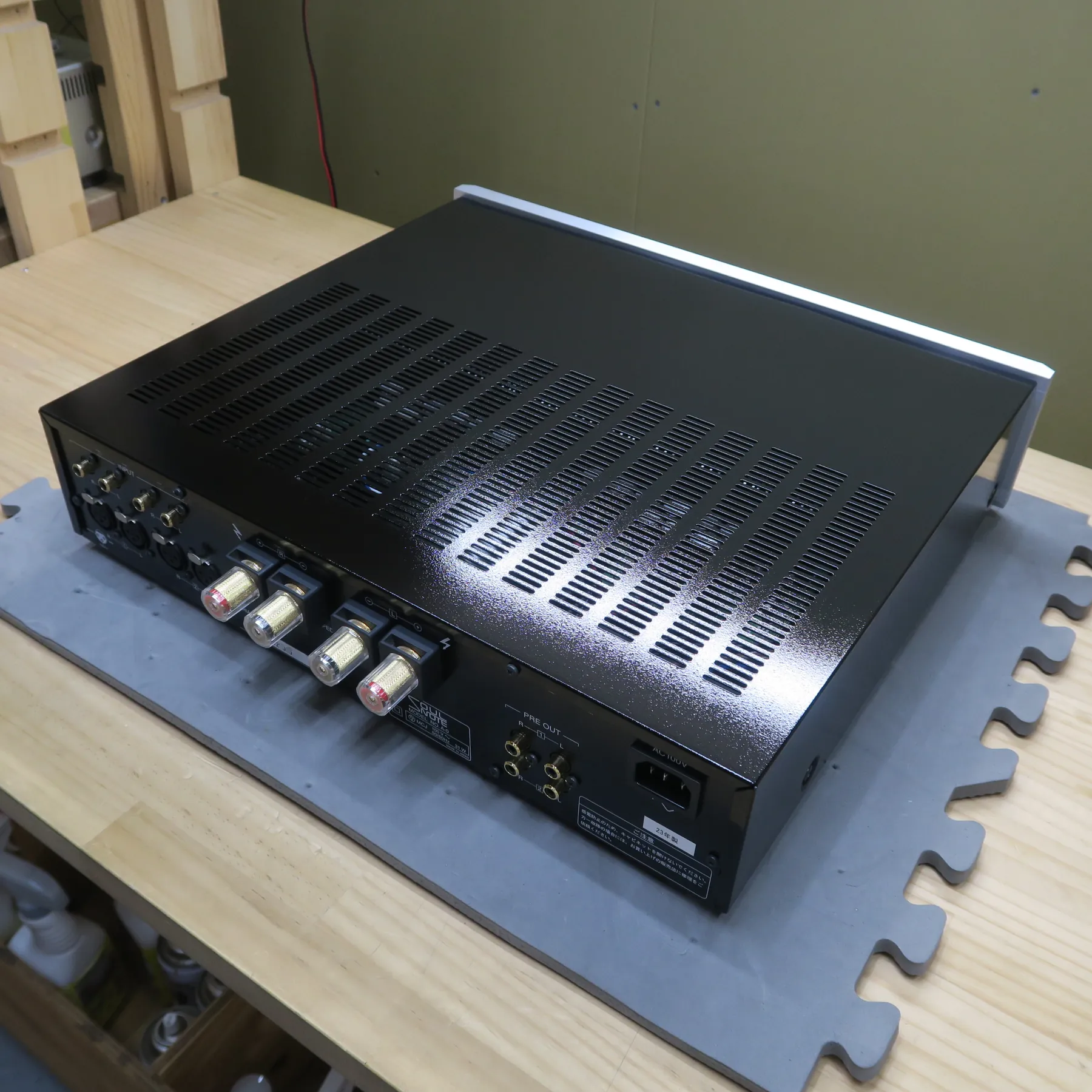 ソウルノート A-0 プリメインアンプの斜め後ろから見た外観、黒色金属製筐体、天板と側面は梨地光沢仕上げ、天板に多数の放熱孔、前面上部に銀色のバー