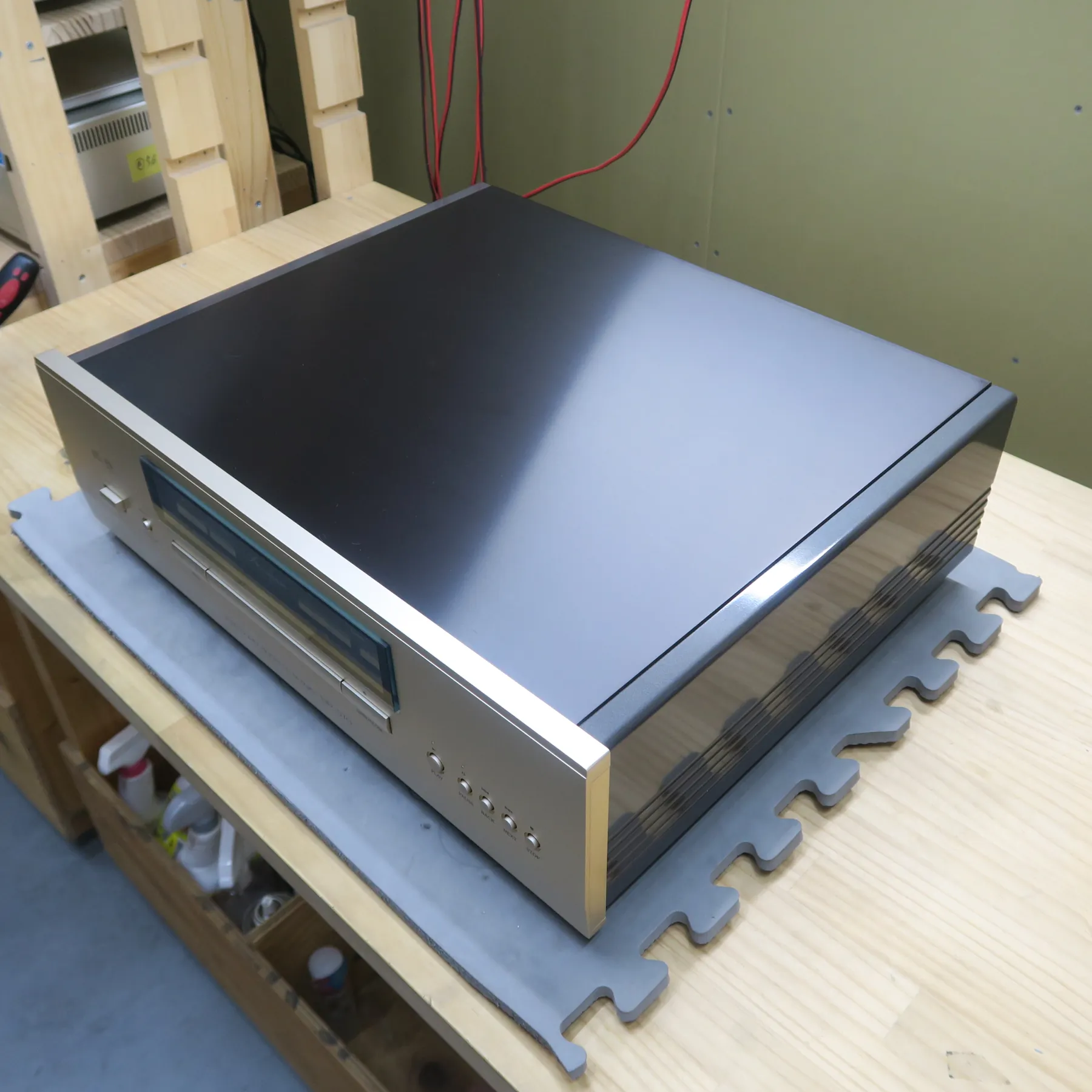 アキュフェーズ DP-570 CDデッキの斜め前から見た外観、前面パネルはシルバーのヘアライン仕上げ、天板と側板は光沢のある黒、右側板には複数の横溝 前面パネルには丸いボタン、横長表示窓、横長トレイ