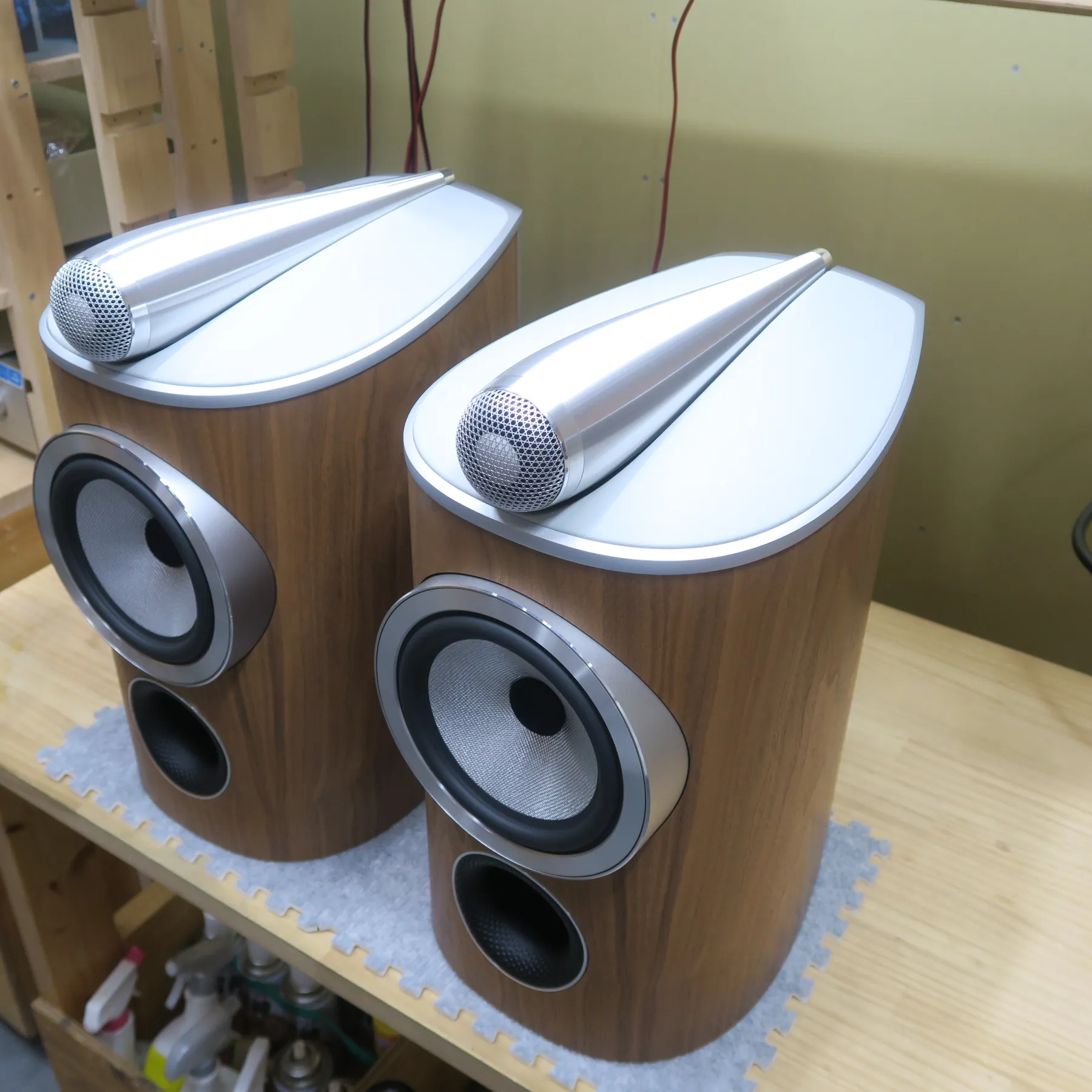 Bowers&Wilkins 805 D4 スピーカーの斜め前から見た外観、縦長の木目調筐体、天板はシルバーのマット仕上げ、上部にシルバーのヘアライン仕上げの流線型ユニット、前面に円形ユニットとポート