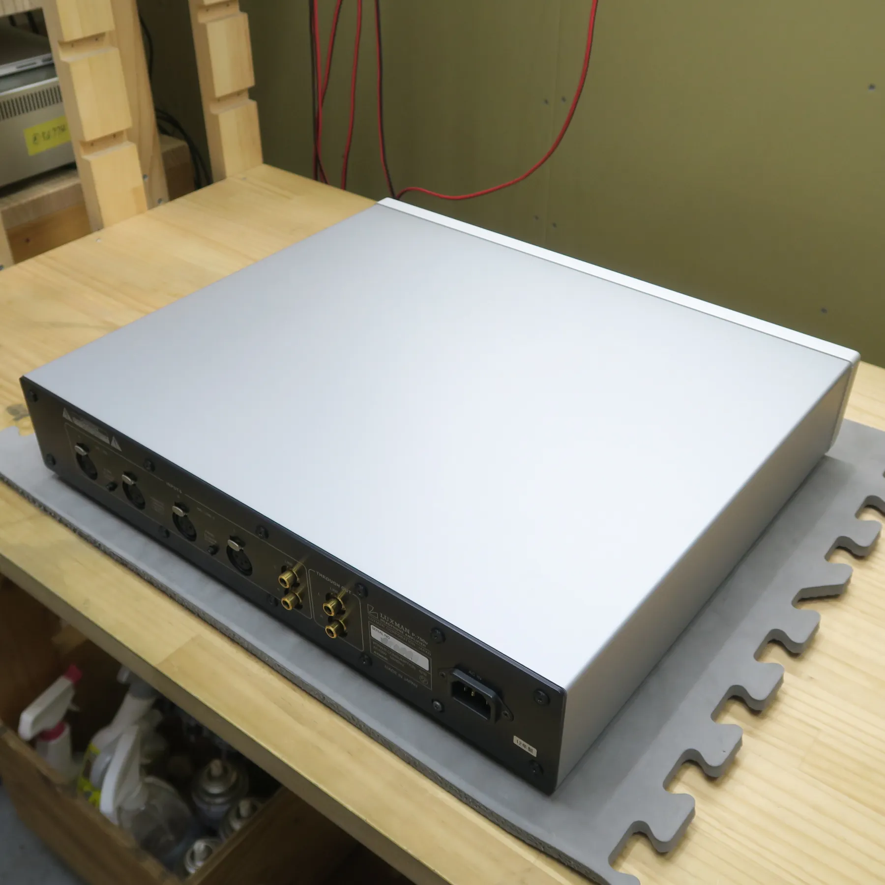 ラックスマン P-700u ヘッドフォンアンプの斜め後ろから見た外観、シルバーの金属製筐体で、天板と側面はマットな質感、背面は黒色パネルで各種入出力端子と電源入力端子がある