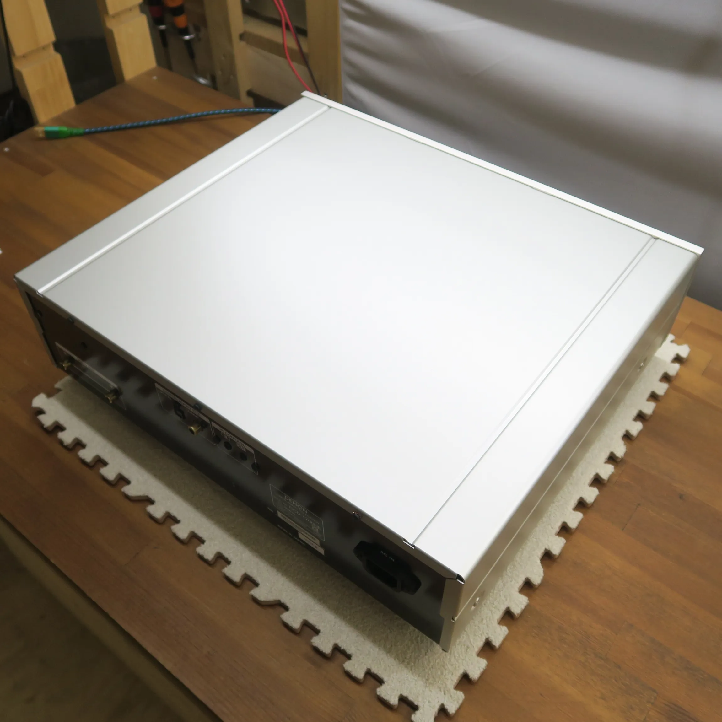 デノン DCD-1700NE CDデッキの斜め後ろから見た外観、薄型直方体筐体、天板はシルバーのヘアライン仕上げ、側面はシルバーのマットな質感、背面は黒