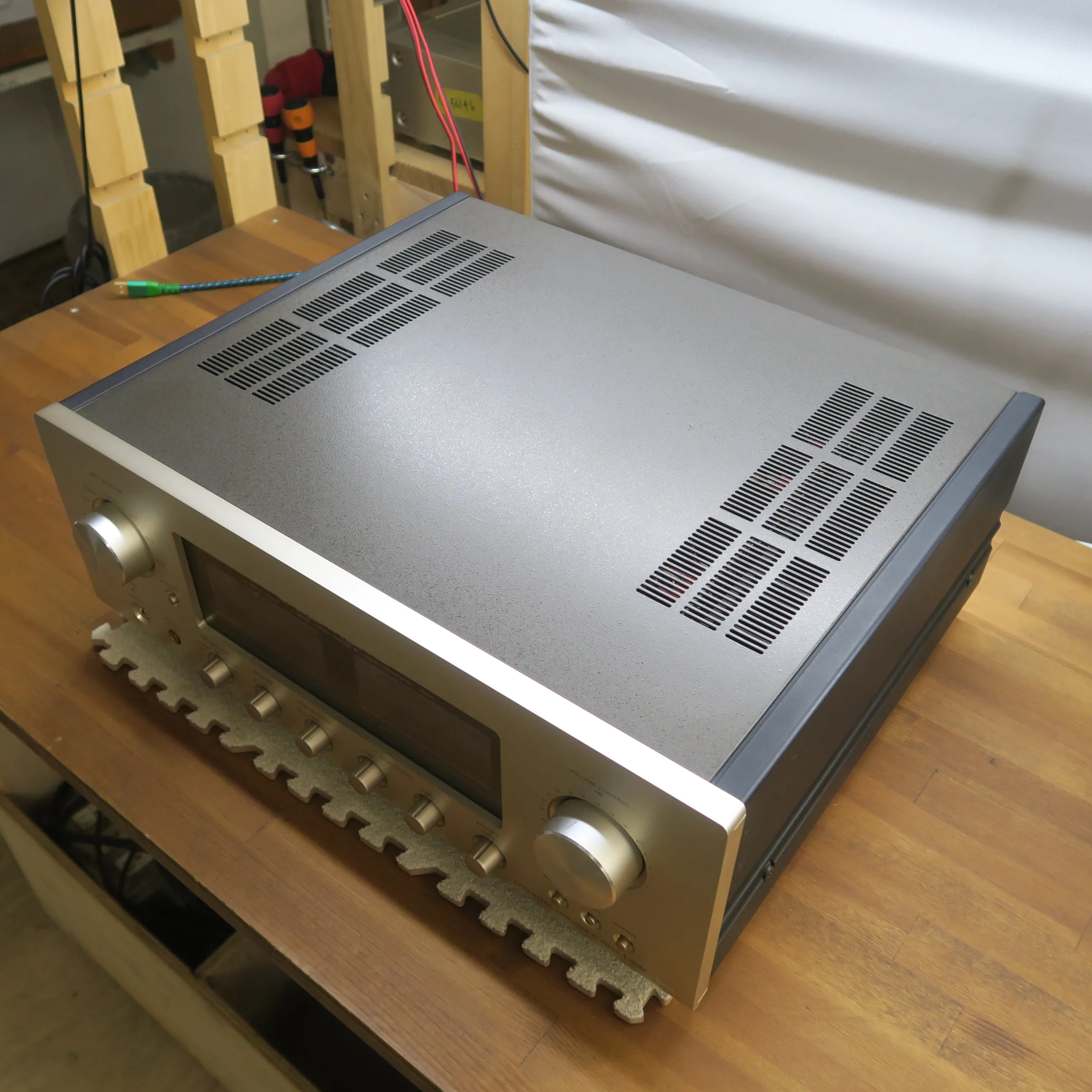 ラックスマン L-505f プリメインアンプの斜め前から見た外観、直方体、前面パネルはシャンパンゴールドのヘアライン金属製、天板はダークグレー梨地金属製で通気孔あり、側板はダークグレー